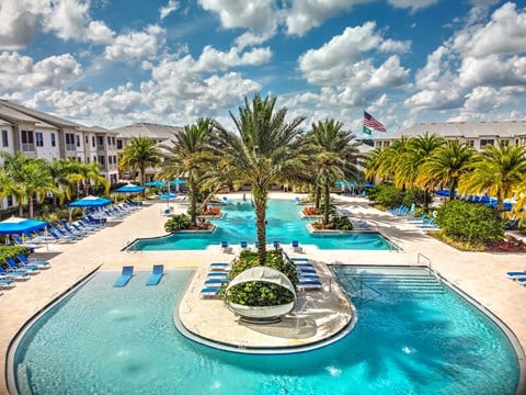 a large swimming pool with a fountain in the middle and a hotel in the background